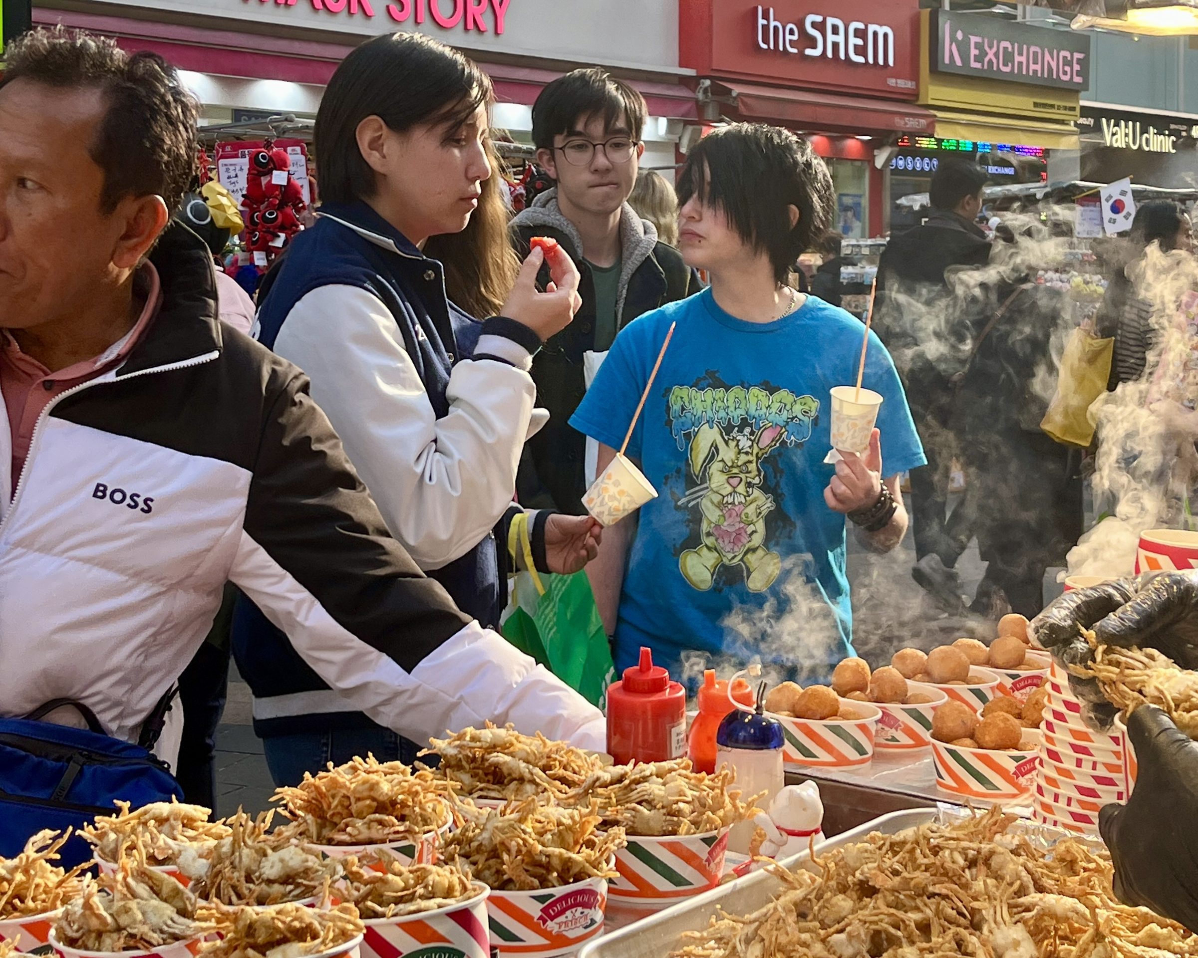 Students choose from a steaming street-food stall on their first evening in Seoul