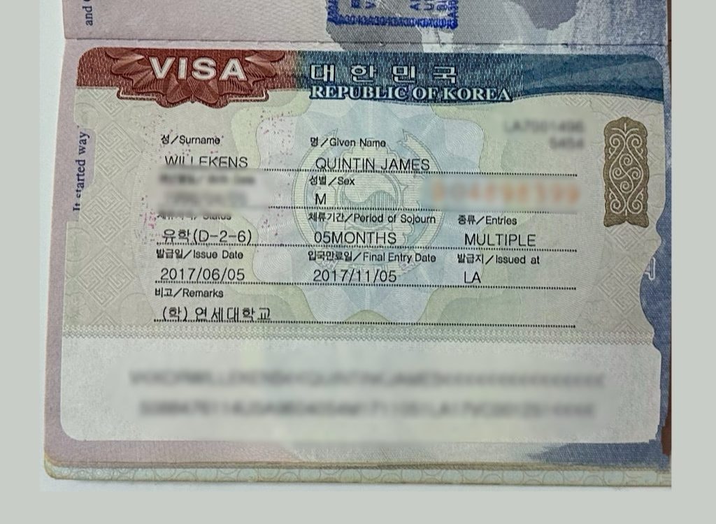 A passport book opened to a visa page with a full-page student visa for South Korea.
