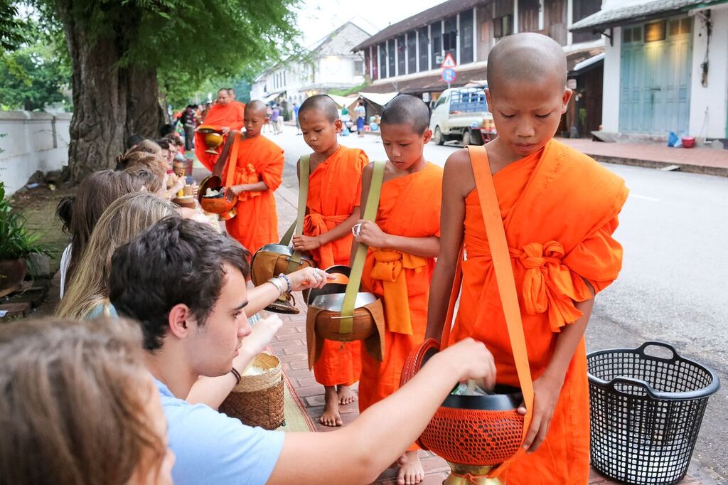 Students in Thailand at a public ceremony in Thailand wiht little boys holding buckets and receiving things.