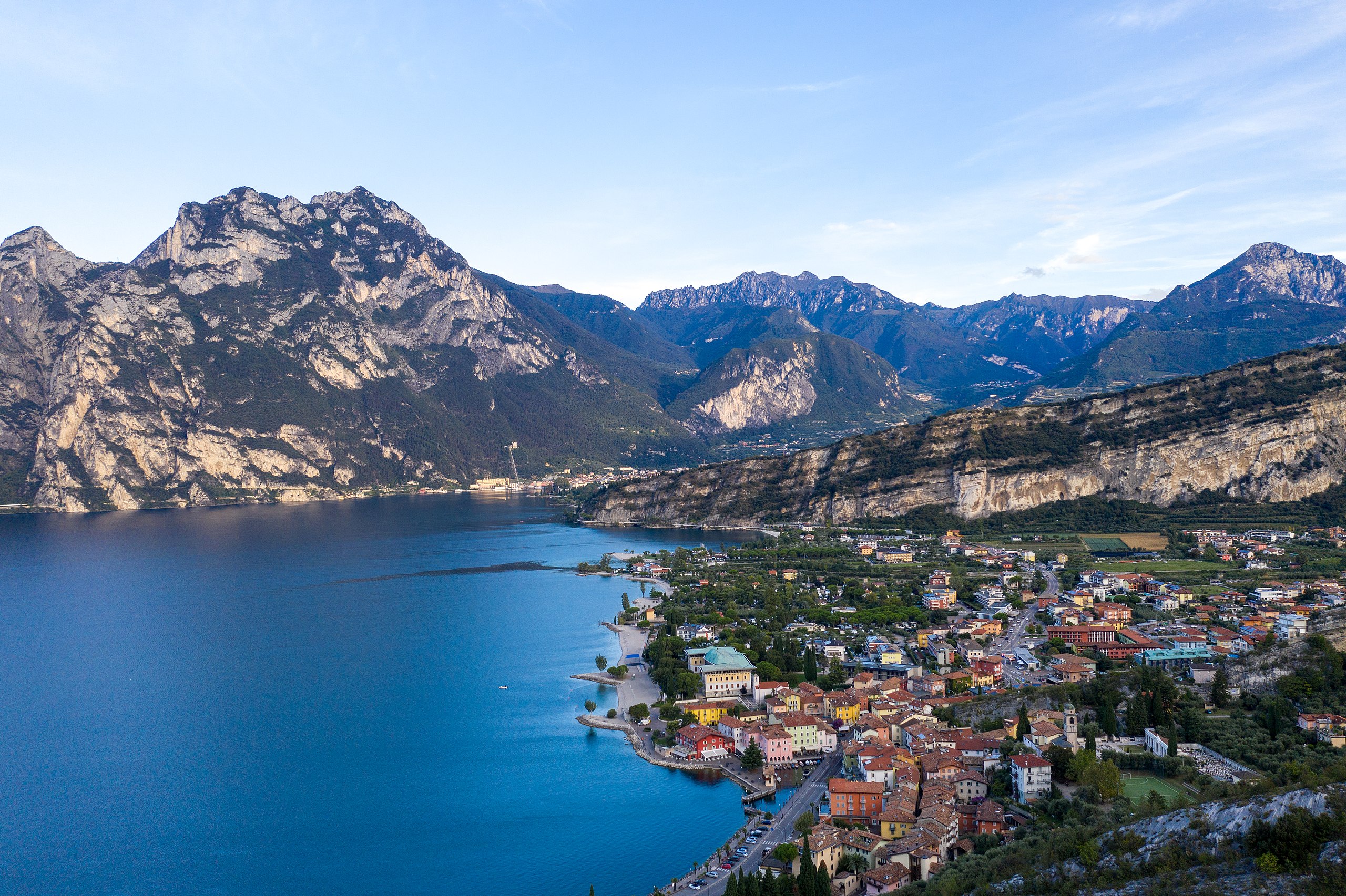 Aerial view of a lakeside town nestled between mountains at Lake Garda