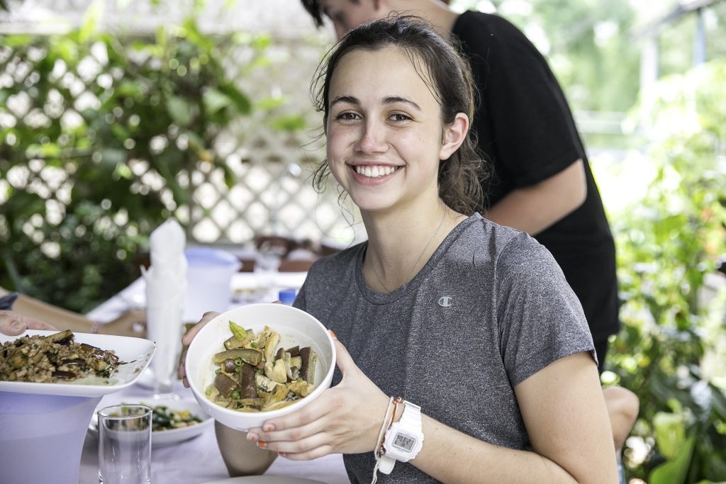 Caucasian girl presents her food on a trip in Laos.