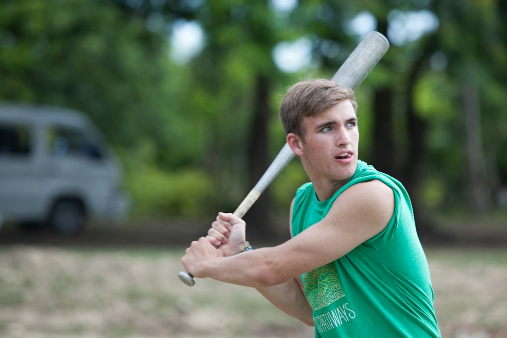 Student playing baseball outdoors as part of a long-term volunteer abroad program combining sports, leadership, and community service.