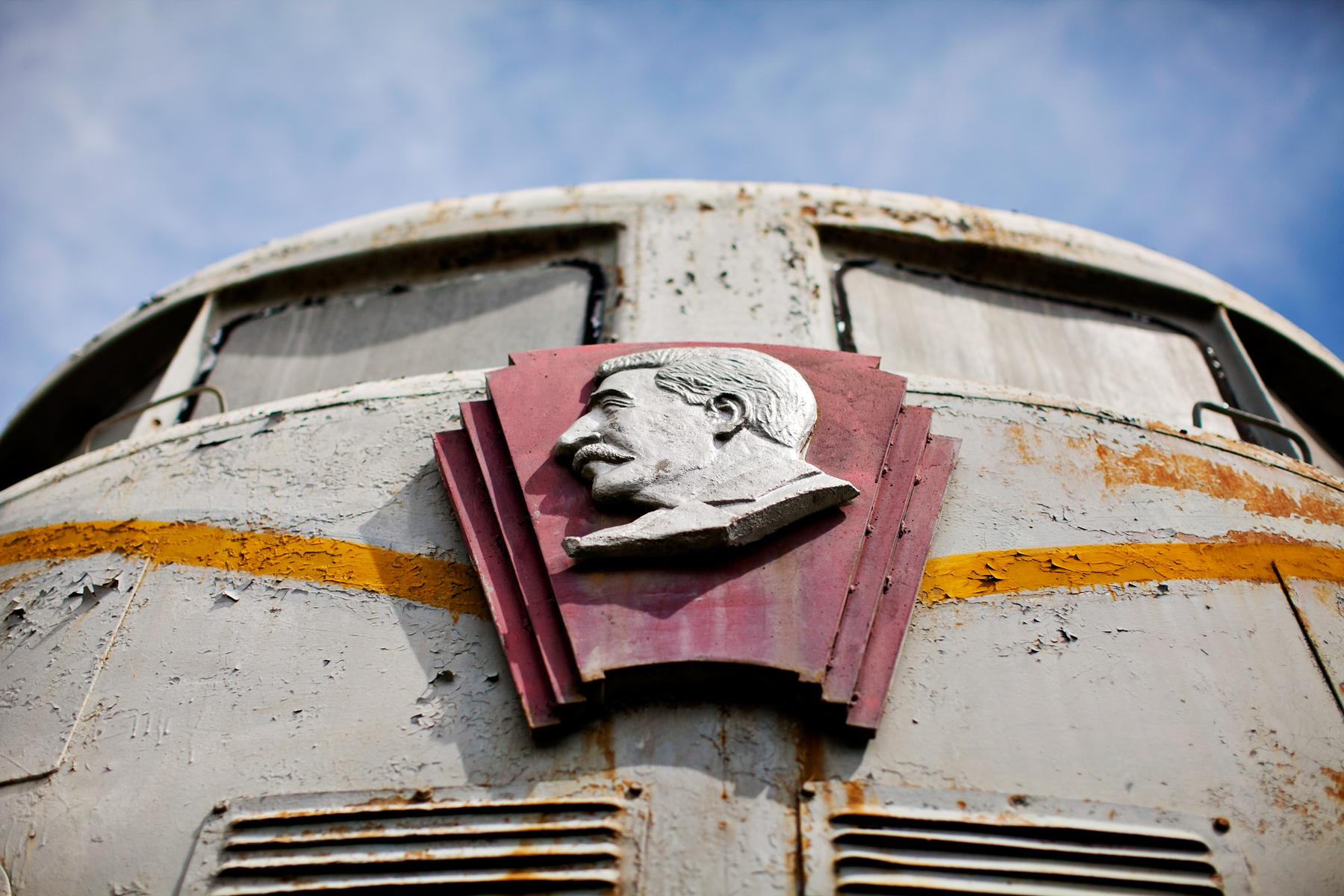 A carved relief portrait bolted to the weathered metal front of a train car