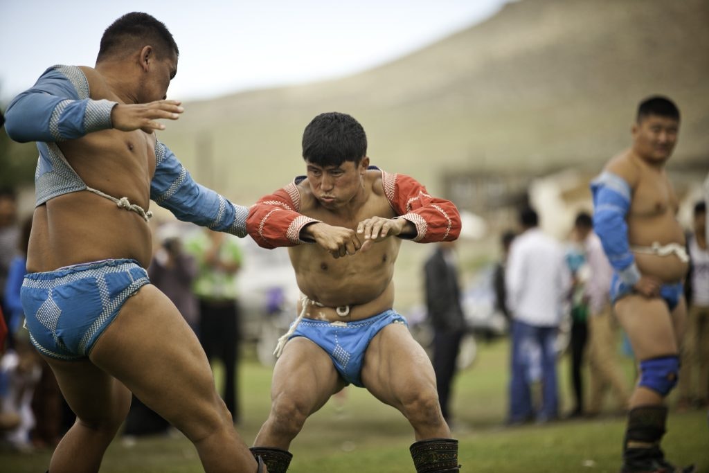 Men in Mongolia practice traditional wrestling in Traditional clothing.