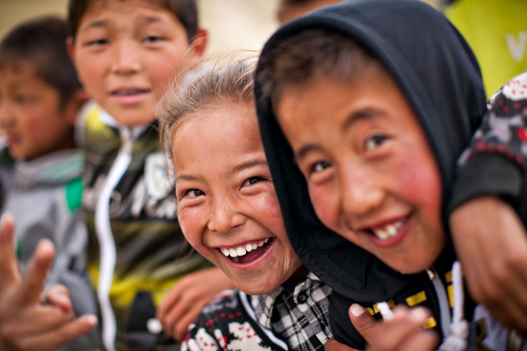 Local children smile and laugh close to the camera