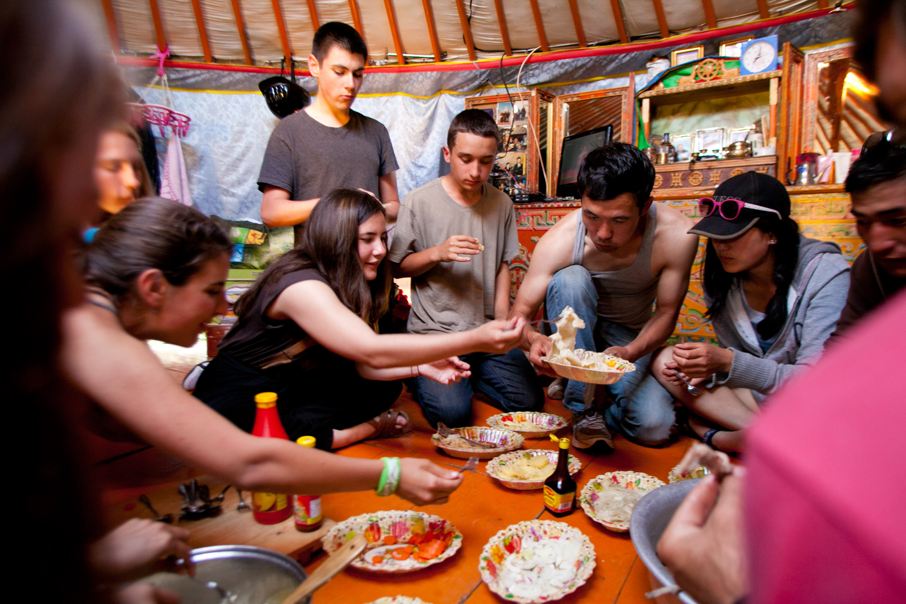 Students share a meal on the floor of a traditional ger