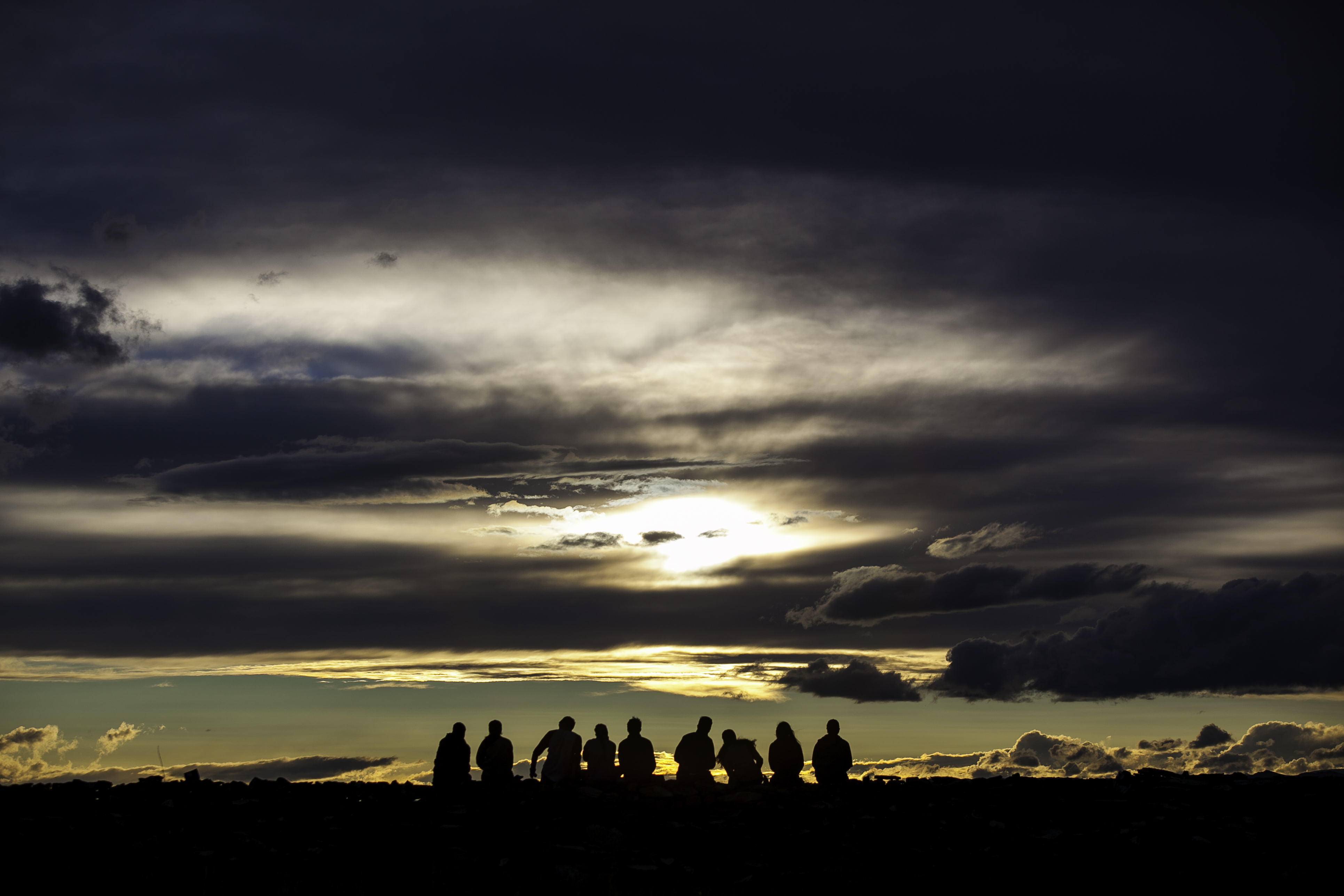 Students in Mongolia silhouetted against a dramatic sunset sky