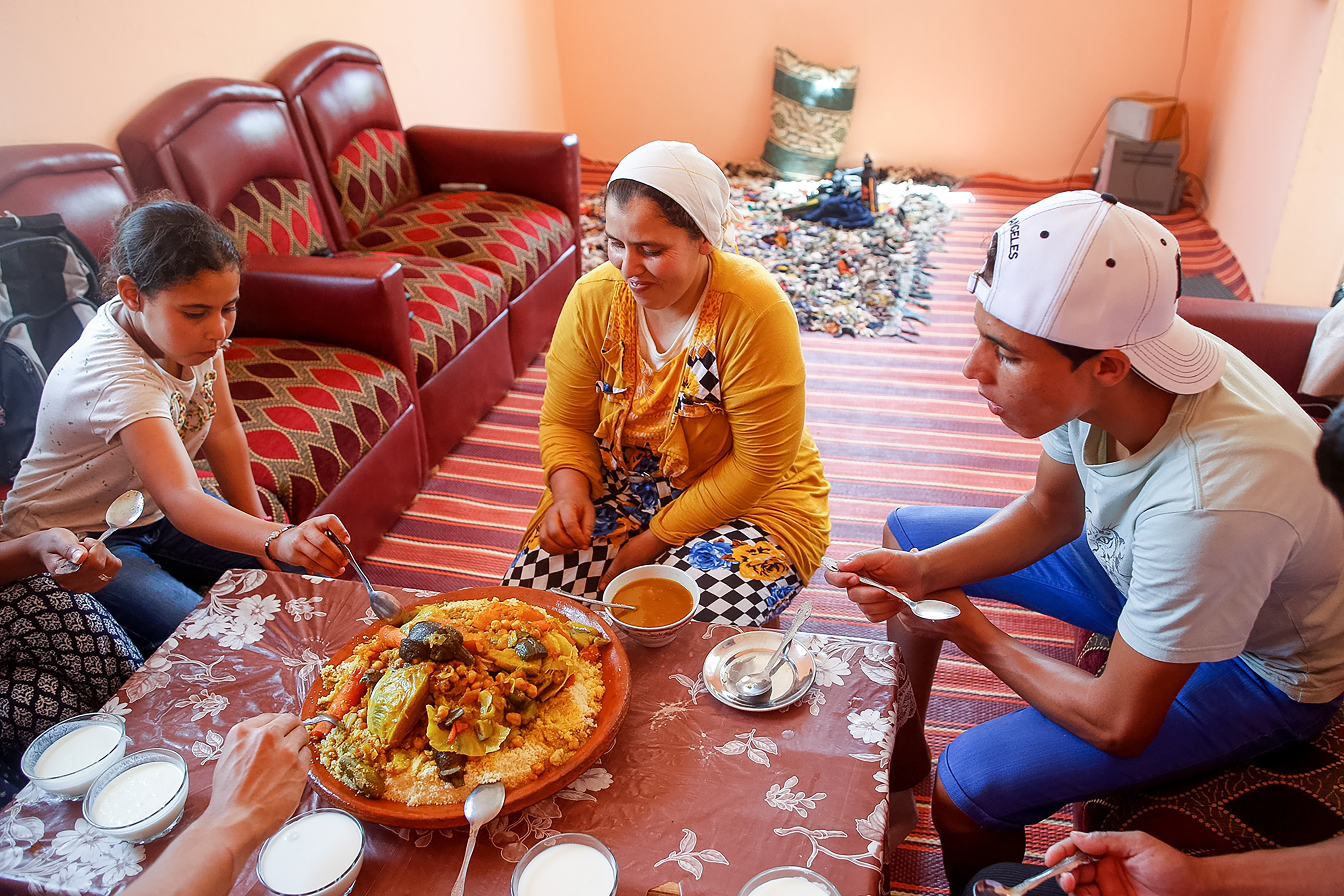 Students share a traditional tagine meal with a host family seated on the floor