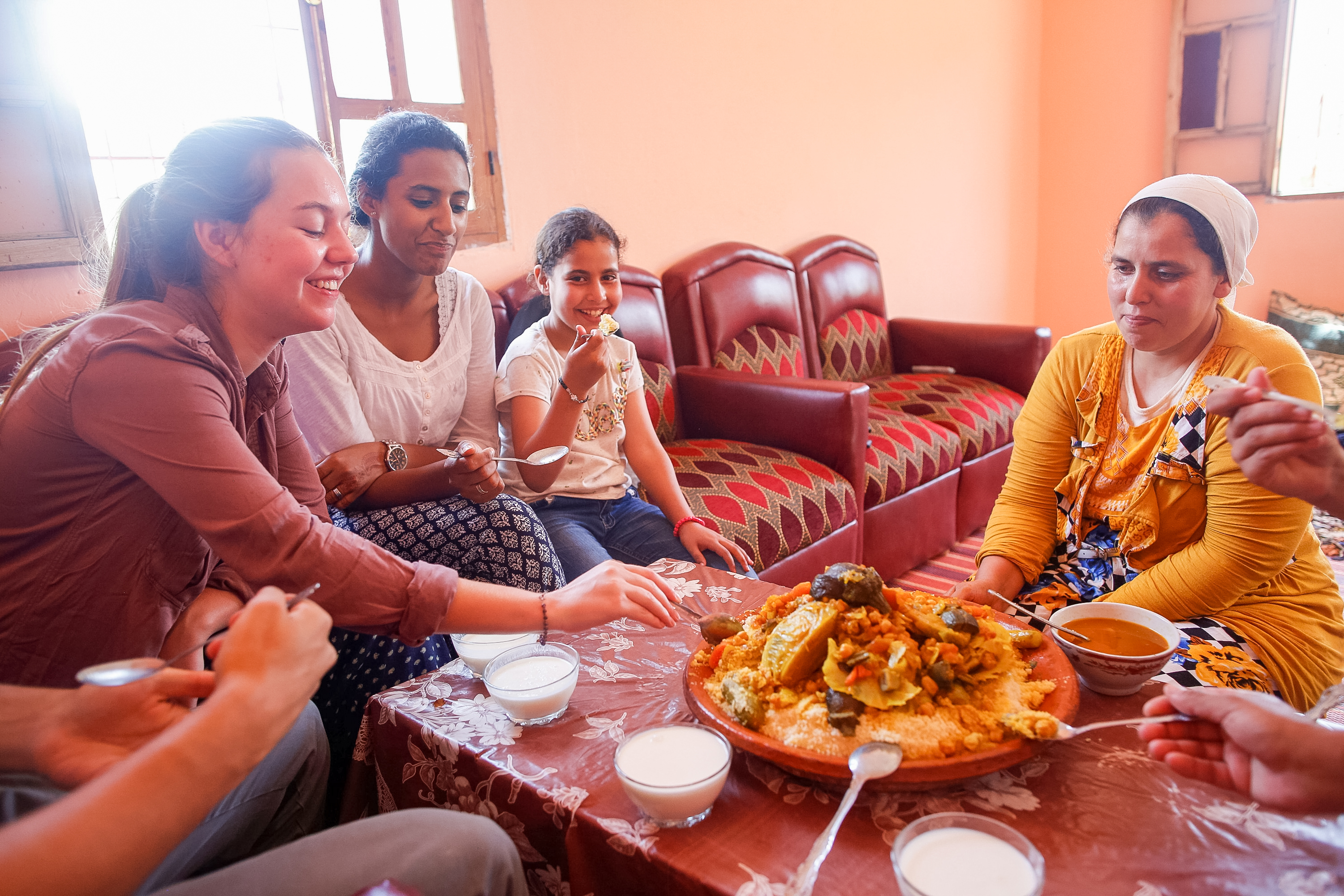 Students in Morocco share a traditional Moroccan meal around a low table with a local host