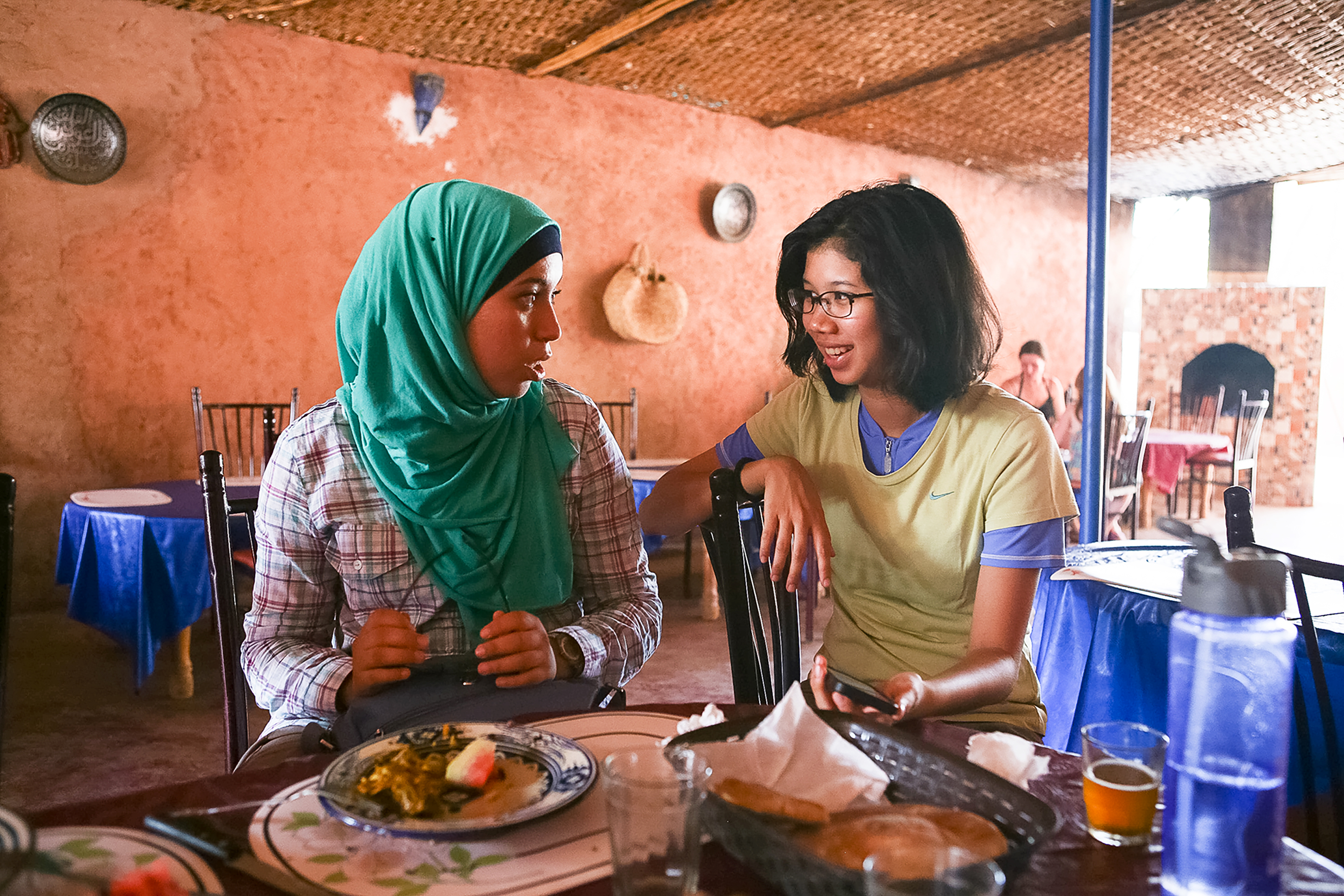 Students chat over a meal at an outdoor restaurant table
