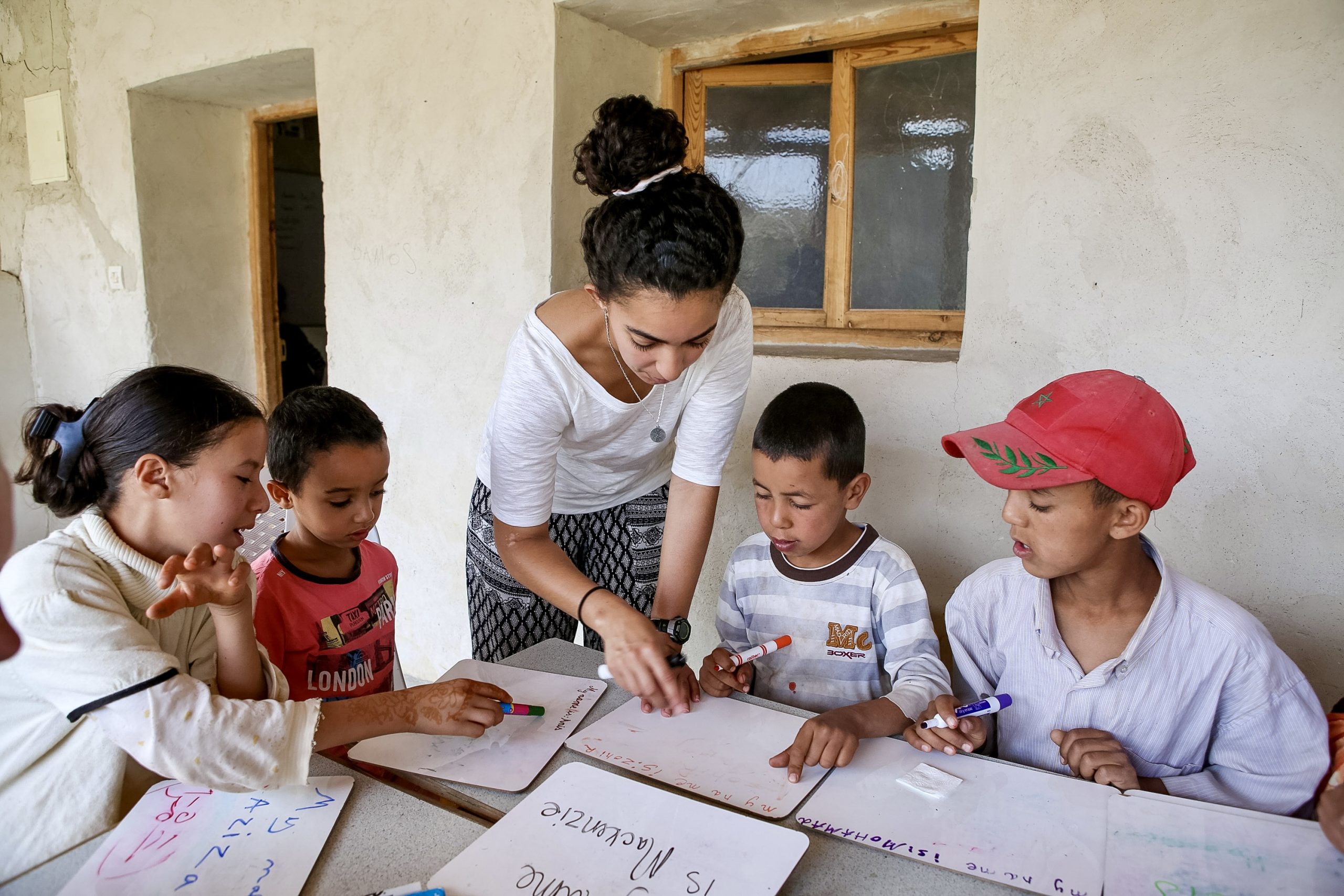 Student volunteer assisting children with lessons in a village classroom in Morocco.