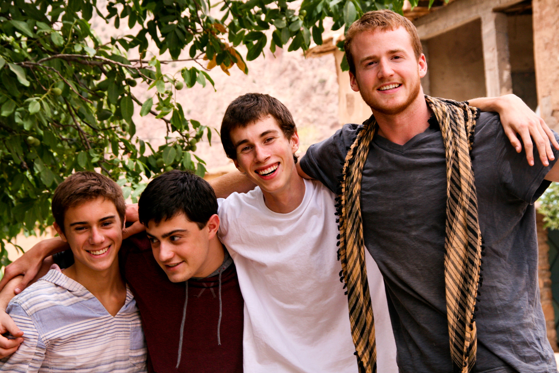 Students smile with arms around each other outdoors