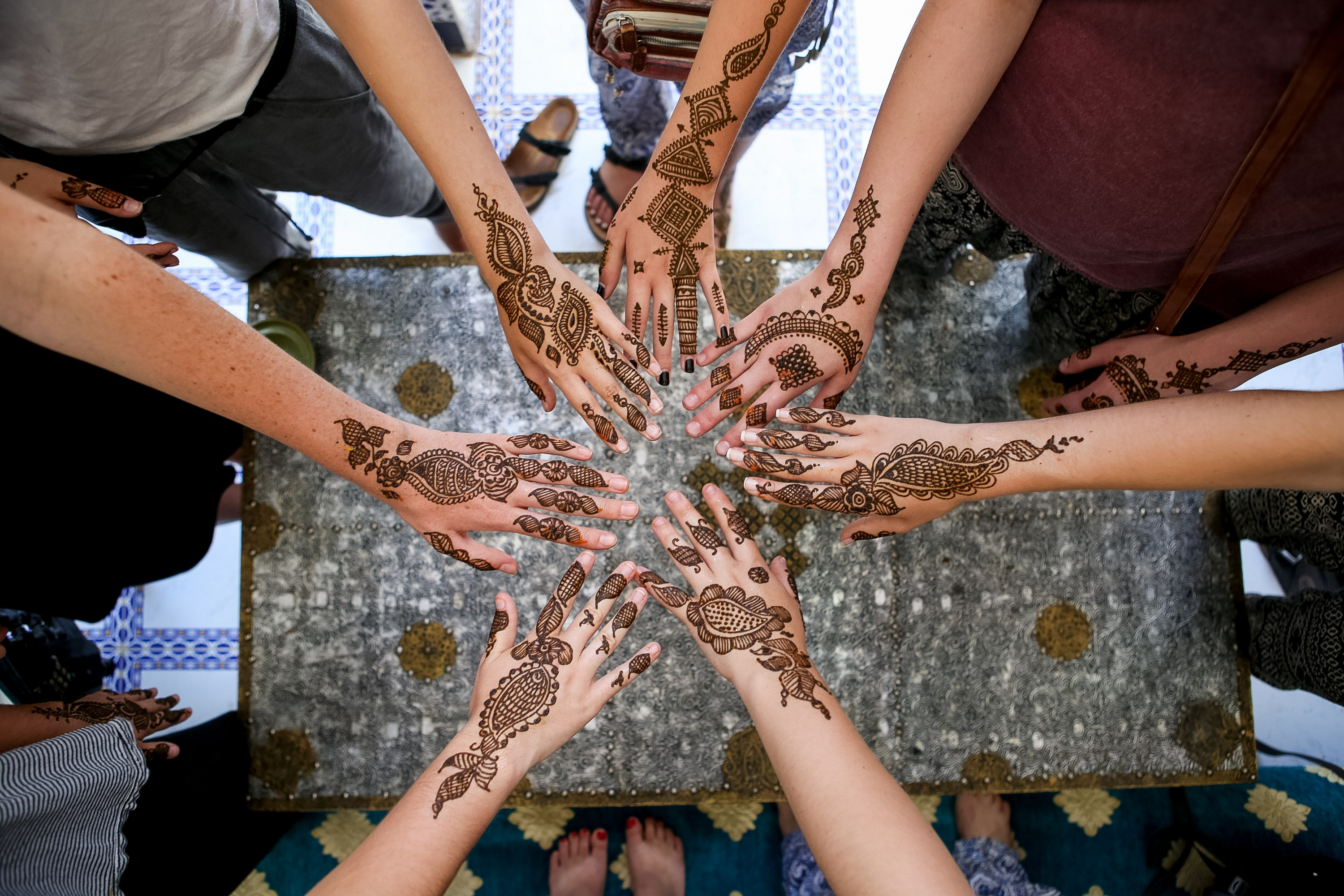Students show off intricate henna designs painted on their hands
