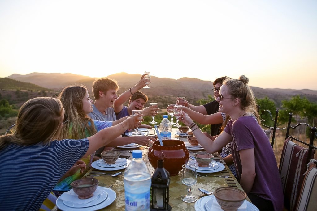 Friends enjoy a dinner by sun set.