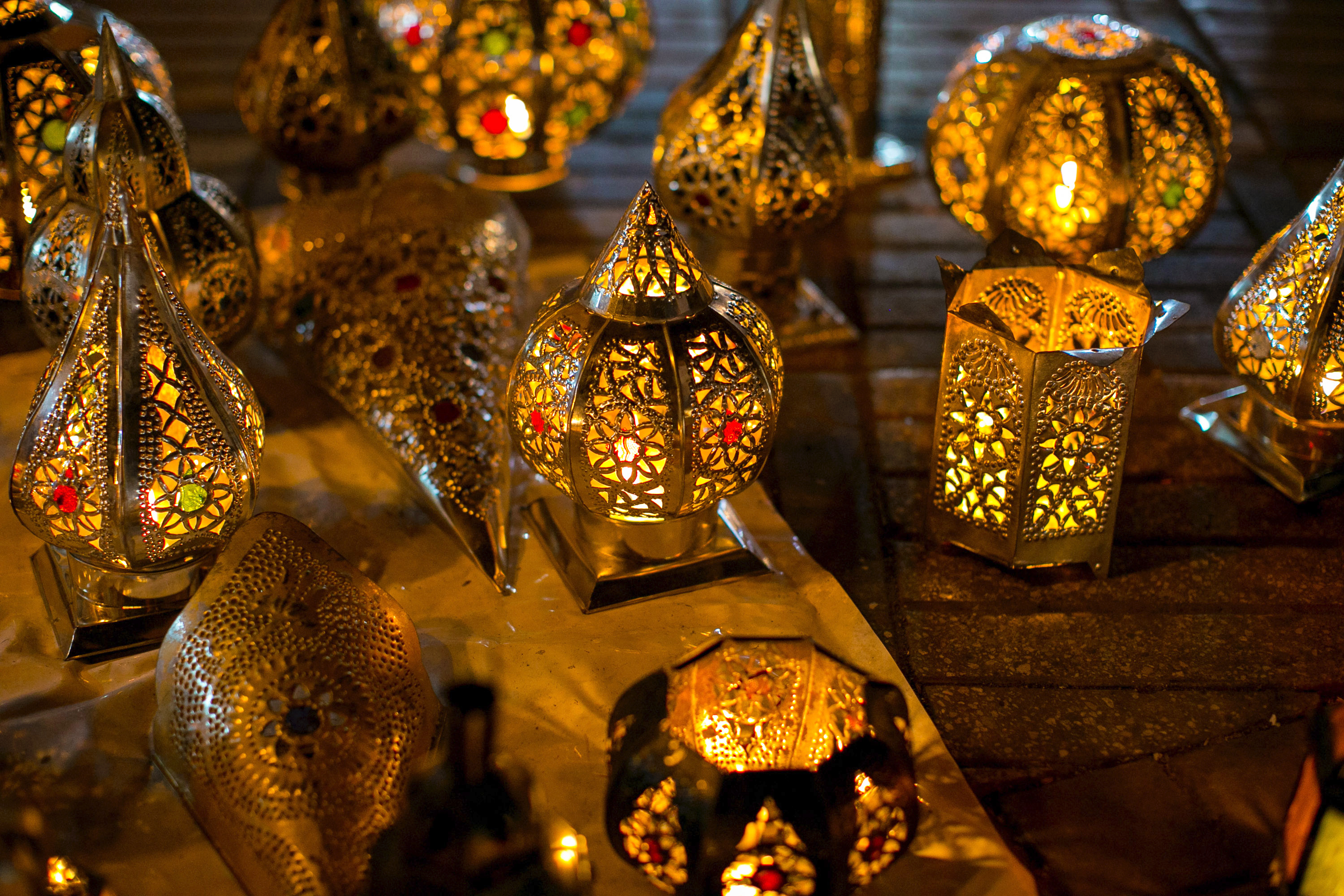 A school trip stops at a market stall where ornate metal lanterns glow with intricate cutout patterns