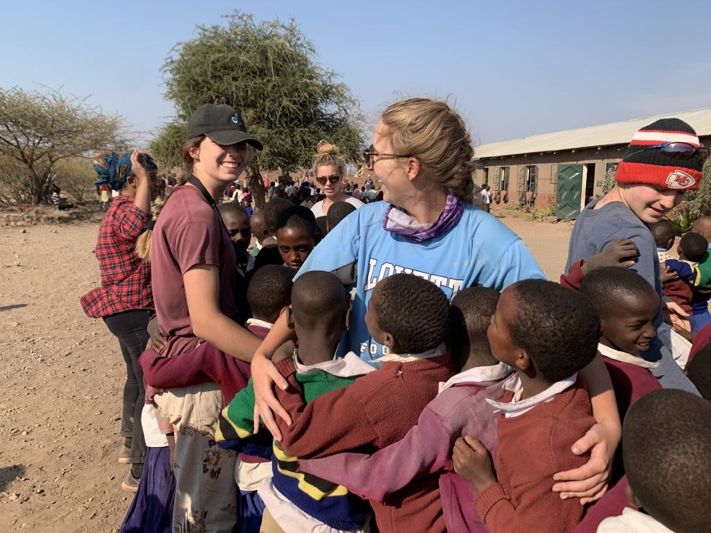 A group of children and students hang out together.