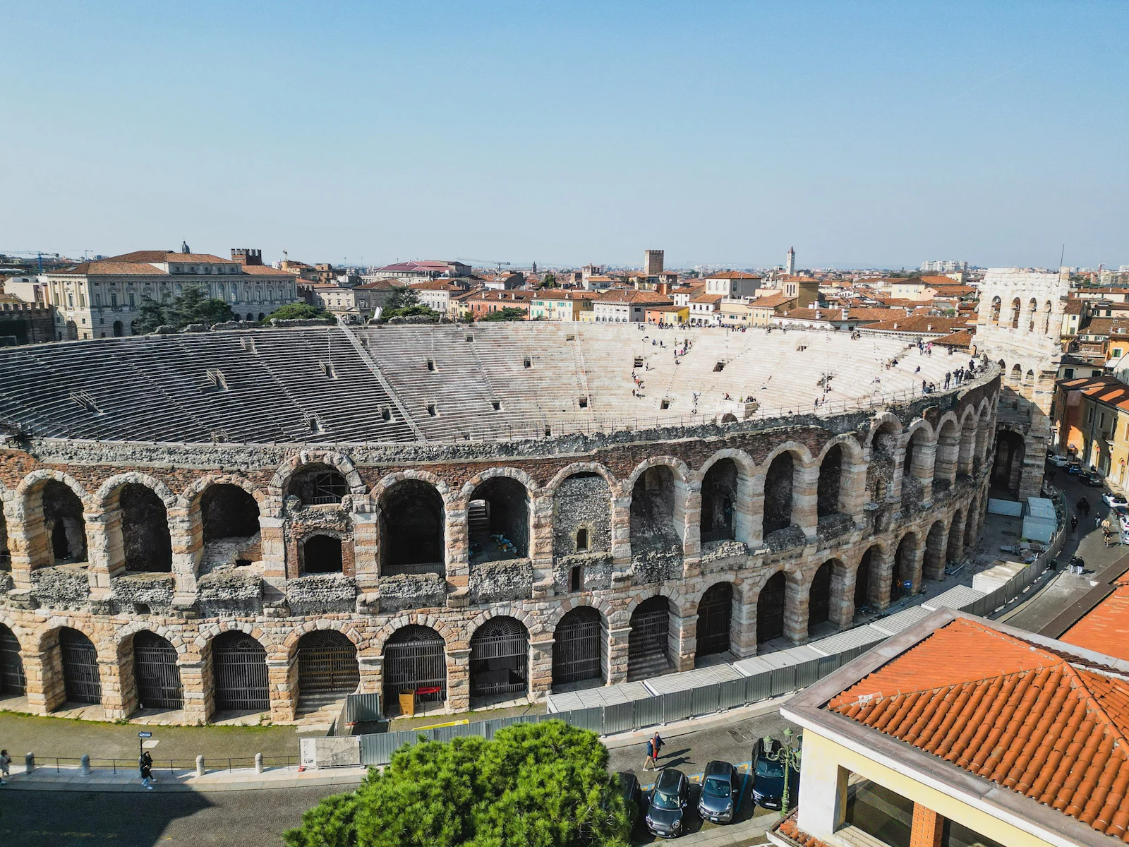 The Roman arena in Verona, Italy, seen from a rooftop above the city's terracotta roofs
