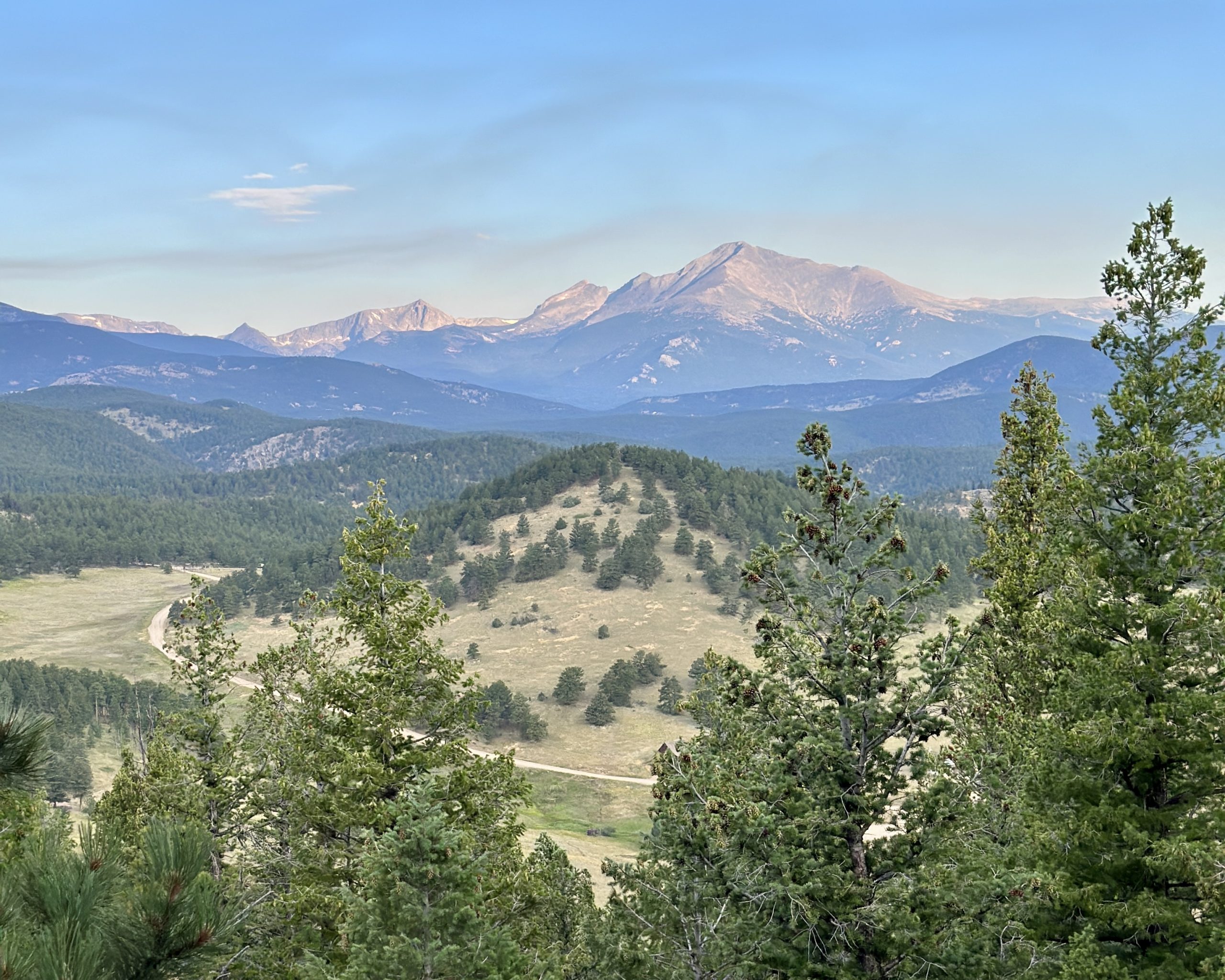 Panoramic view of the Colorado Rockies and forested valleys near Denver, photographed during an outdoor camp hike.