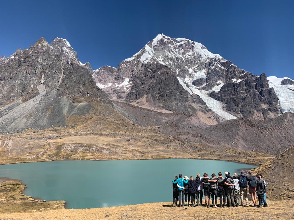 Students in Peru looking at lake and mountains in the background.