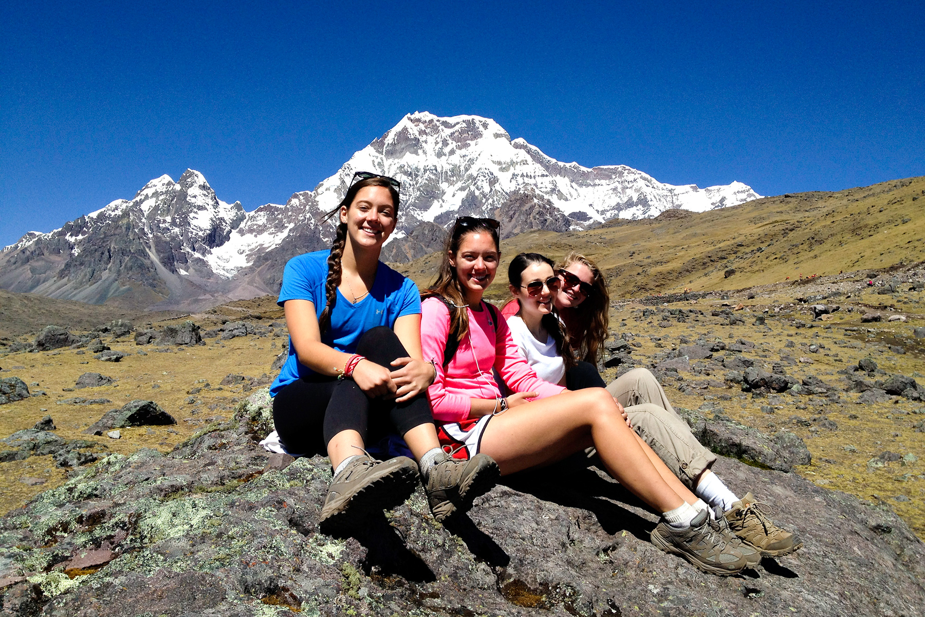 A group of teen travelers take a break during a hike on an adventure teen tour.