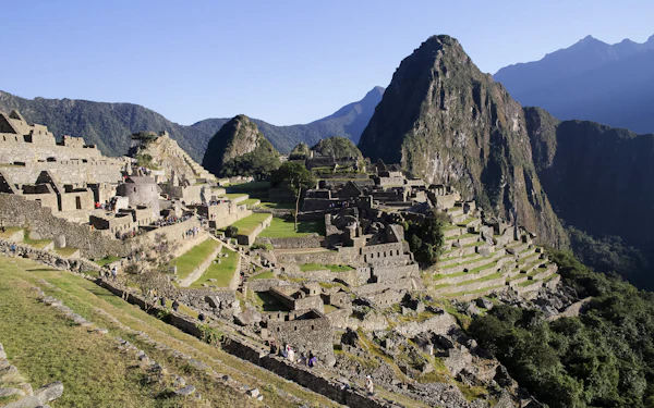 Machu Picchu's terraces and stone buildings in morning light, Huayna Picchu rising behind