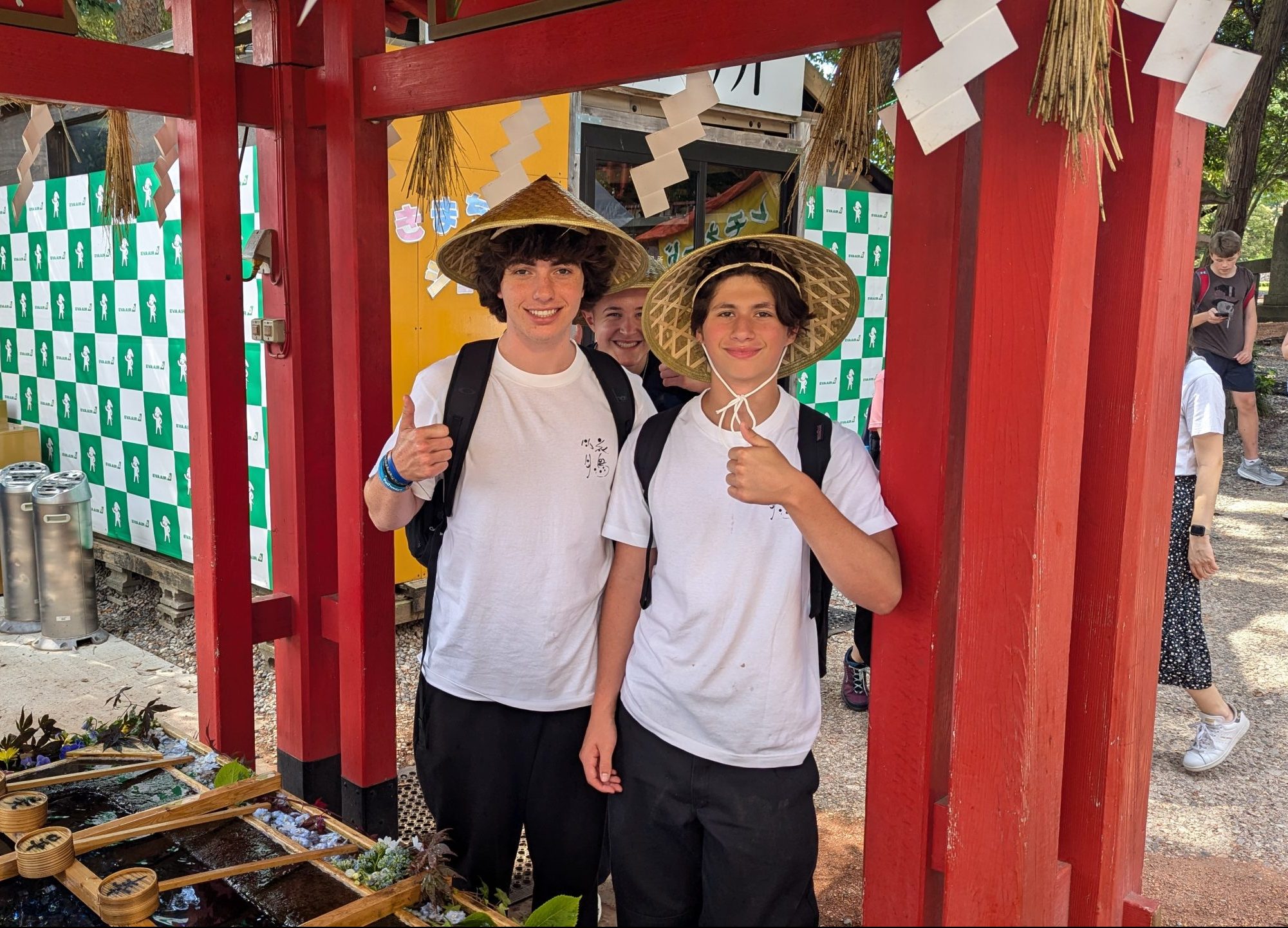 Two boys in straw hats stand next to a water fountain in Tokyo. fun facts about tokyo