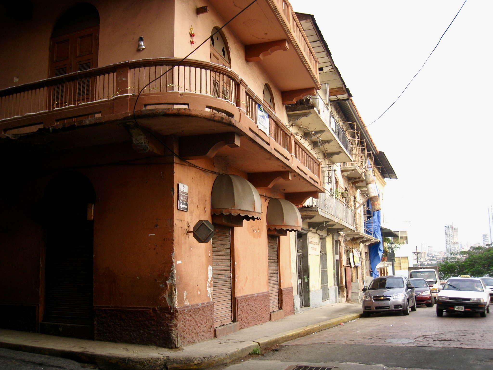 Weathered colonial buildings with balconies line a street corner in Casco Viejo