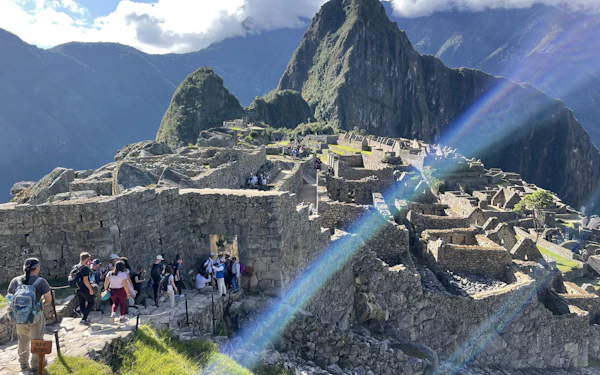 Students walk the stone paths of Machu Picchu with the peak and terraces beyond