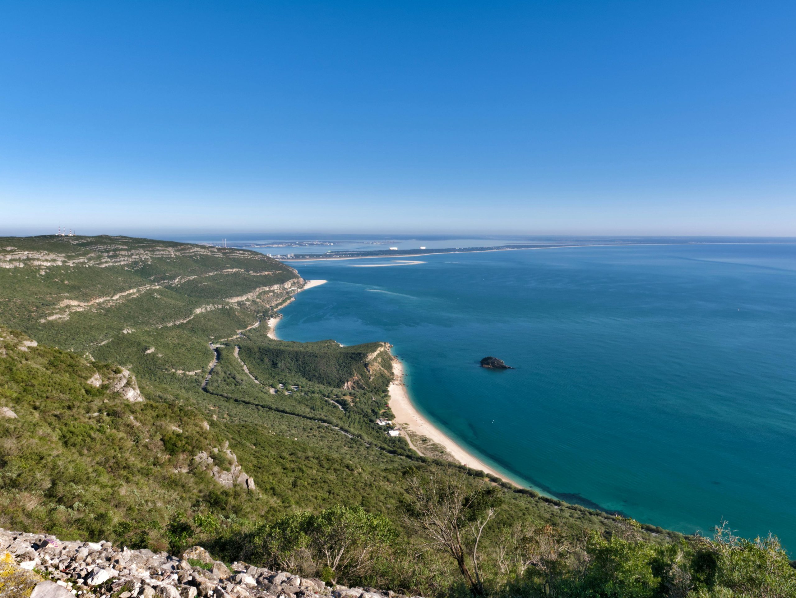 Students take in a coastal overlook of a sandy beach and cove along Portugal's Arrábida coastline