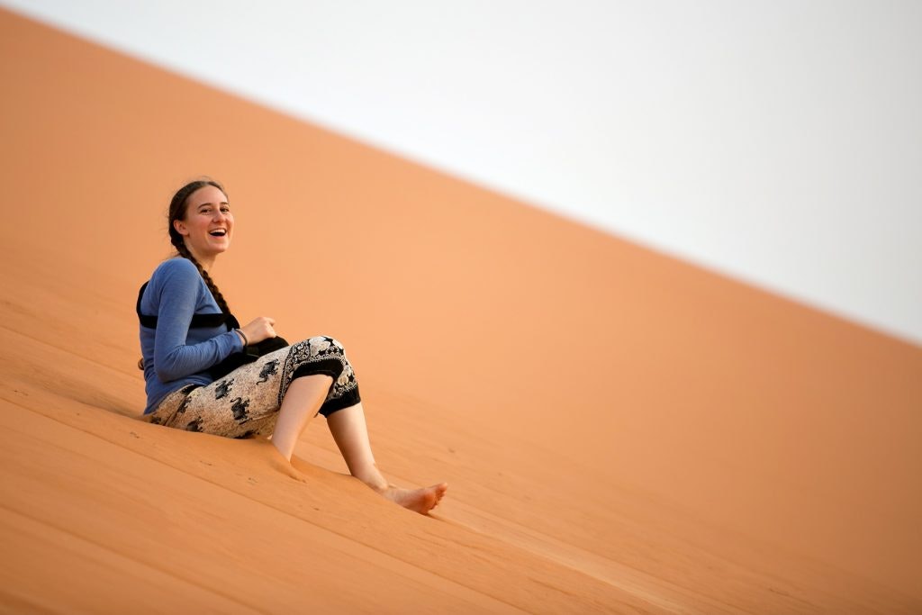 Student on a sand dune in the Sahara Desert