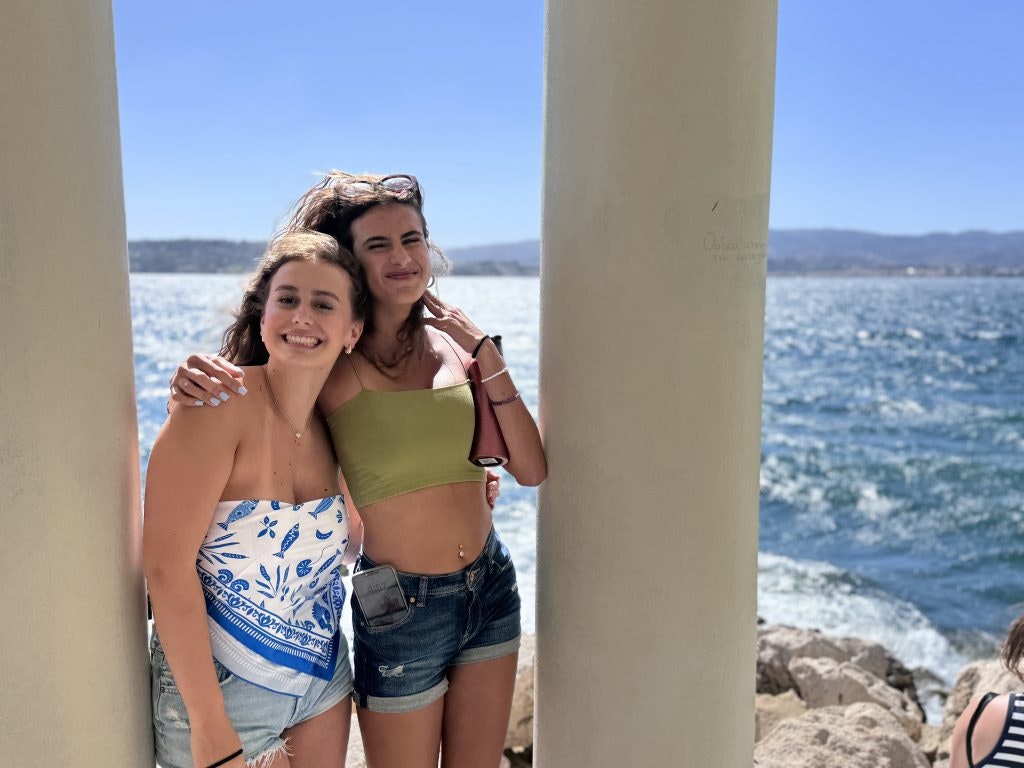 Two teen tour participants at a monument by the ocean during a teen tour in Europe.