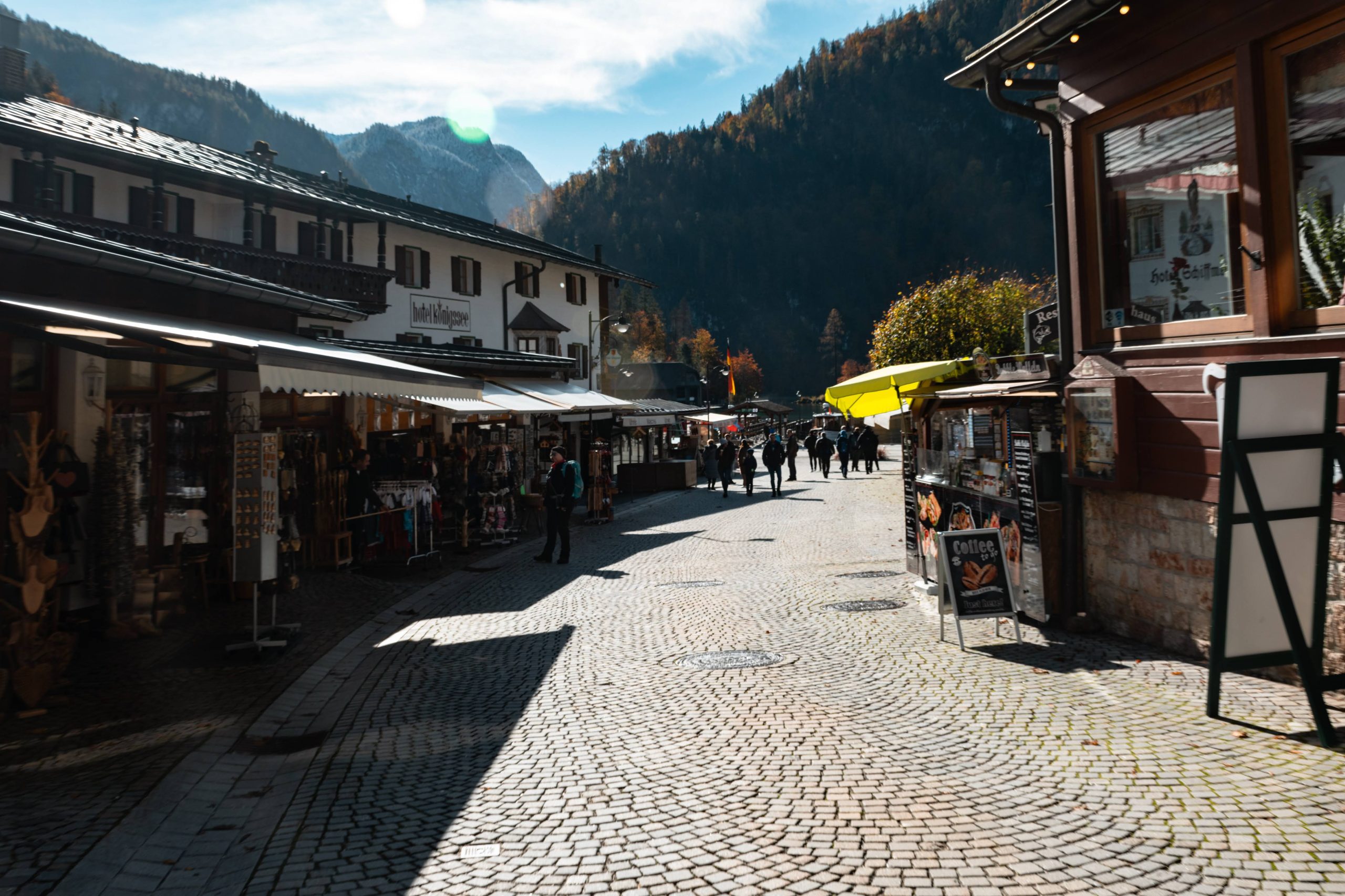 A charming street in a mountain town lined with shops and people.