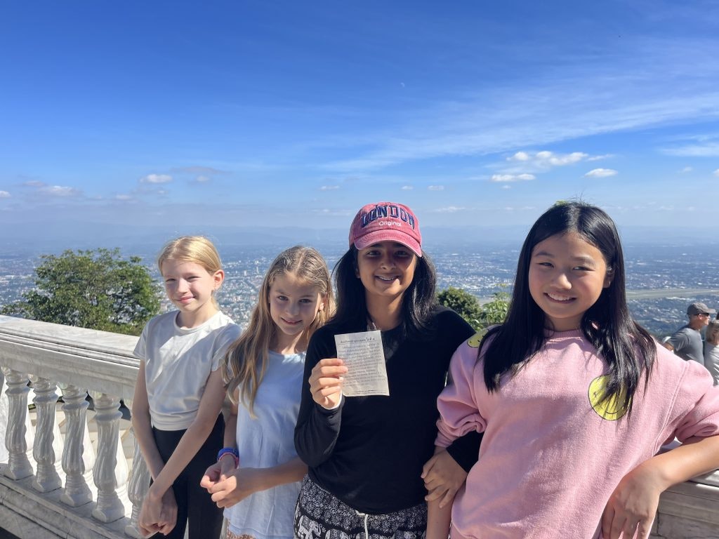 Four young teen travelers pose at a viewpoint in Thailand during a student travel program abroad.