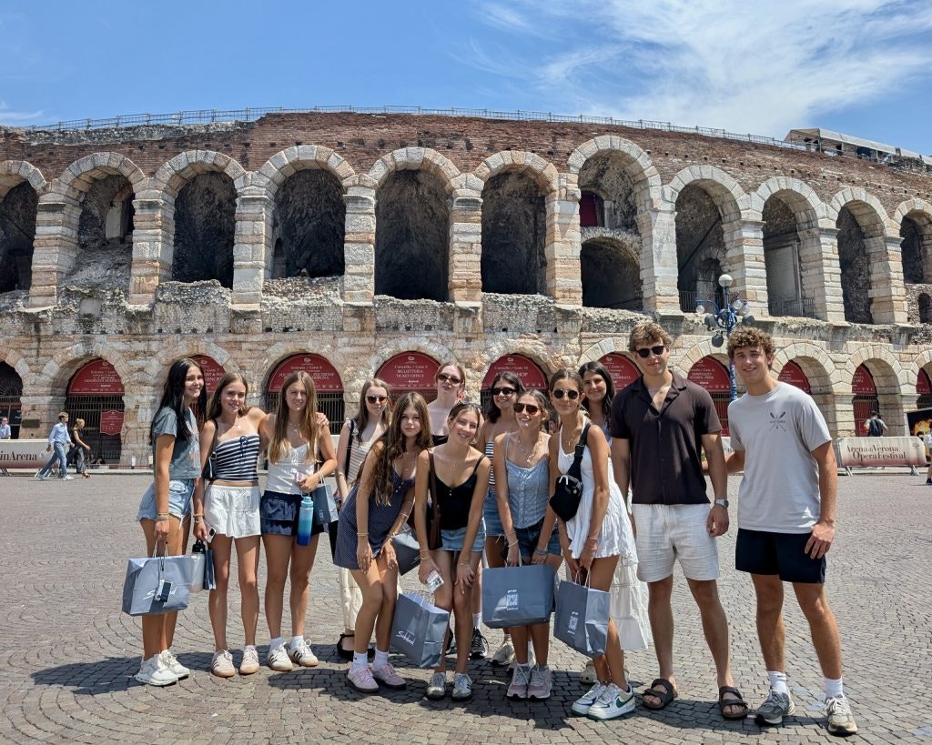 A group of students pose in front of an ancient Roman amphitheater during an Italy teen tour