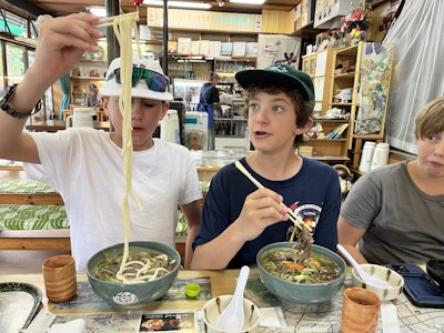 Student travelers eating noodles at a restaurant in Tokyo during a summer teen tour.