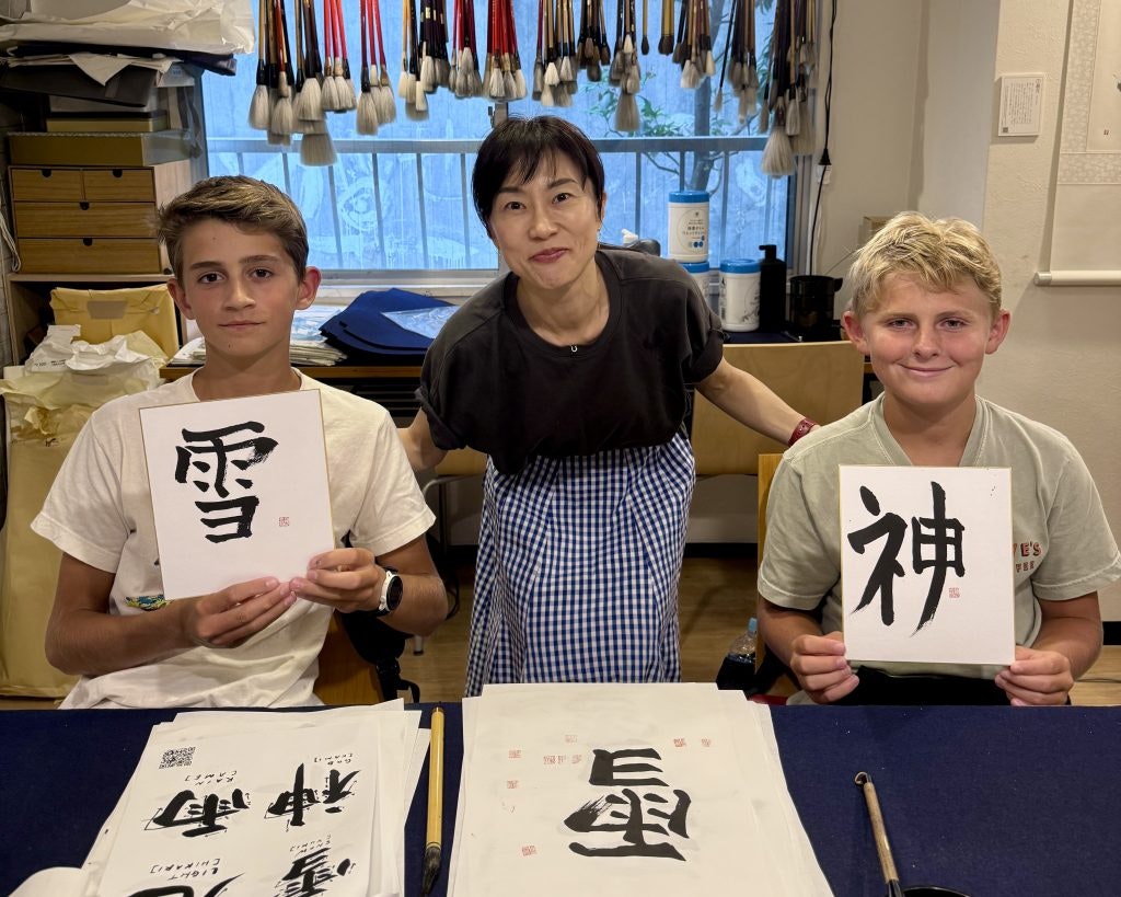 Two teen travelers pose with their instructor during a language immersion class in Tokyo, Japan.