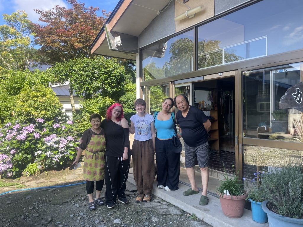 Teen travelers posing with a homestay host family on a Rustic Pathways summer teen travel program.