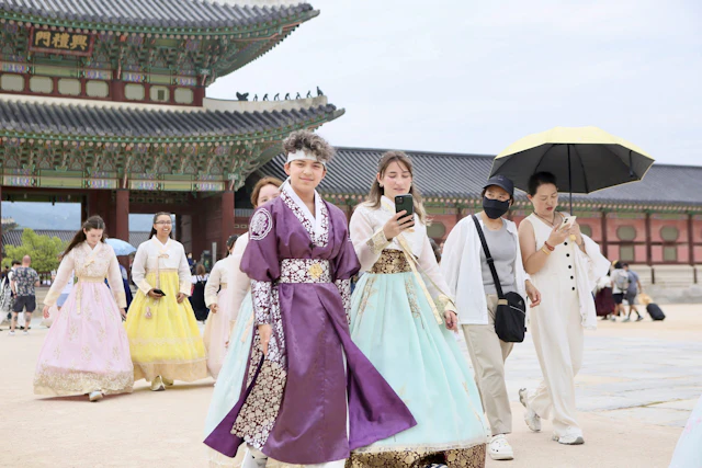 Students in rented hanbok walk across the courtyard of Gyeongbokgung Palace in Seoul