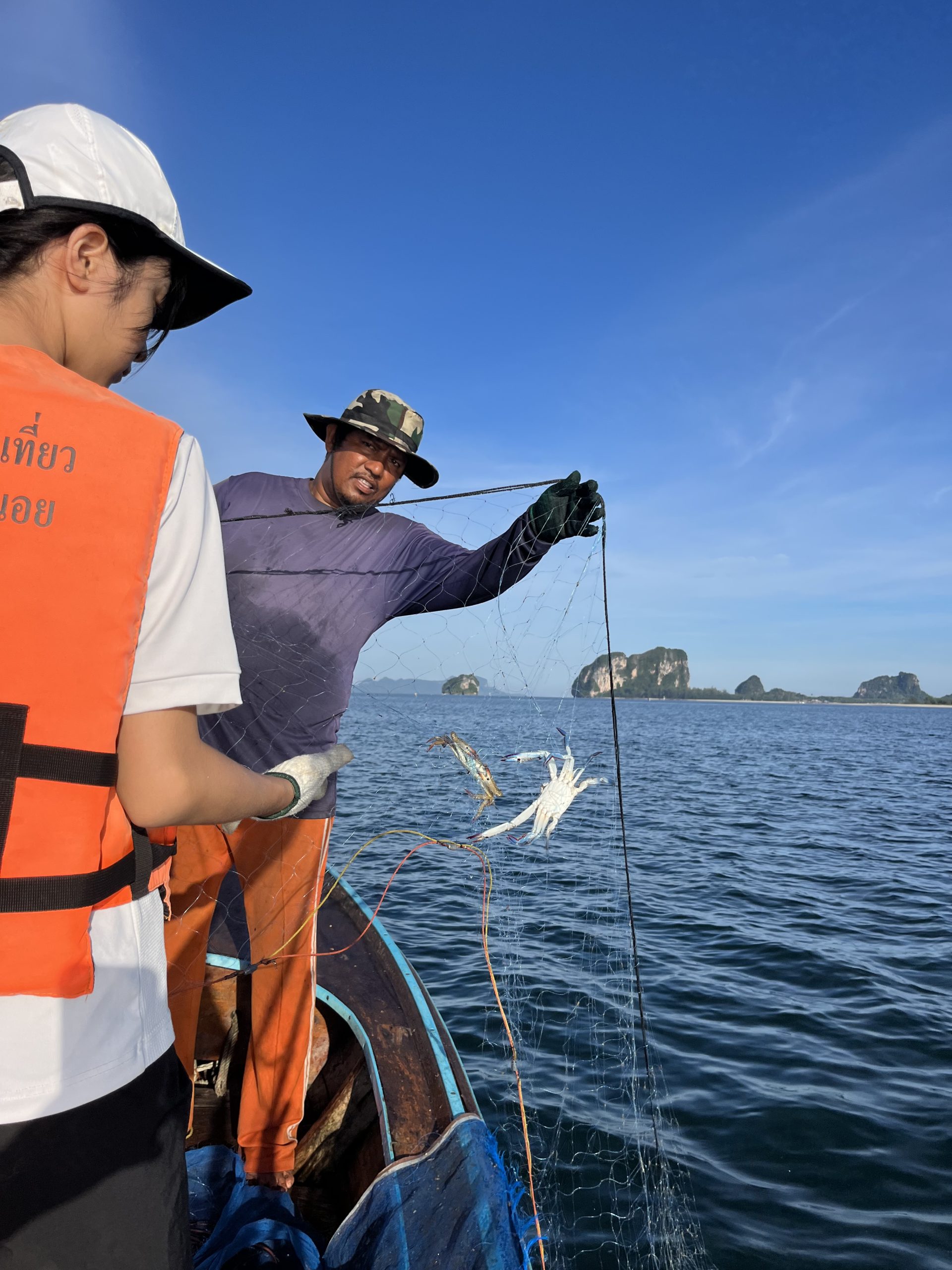 Fun Facts about Pattaya #1: Pattaya was a fishing villageOn a boat trip with students, a fisherman proudly displays two catches for the camera.