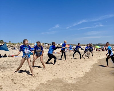 A group of students get a surf lesson on the beach during a spain teen tour