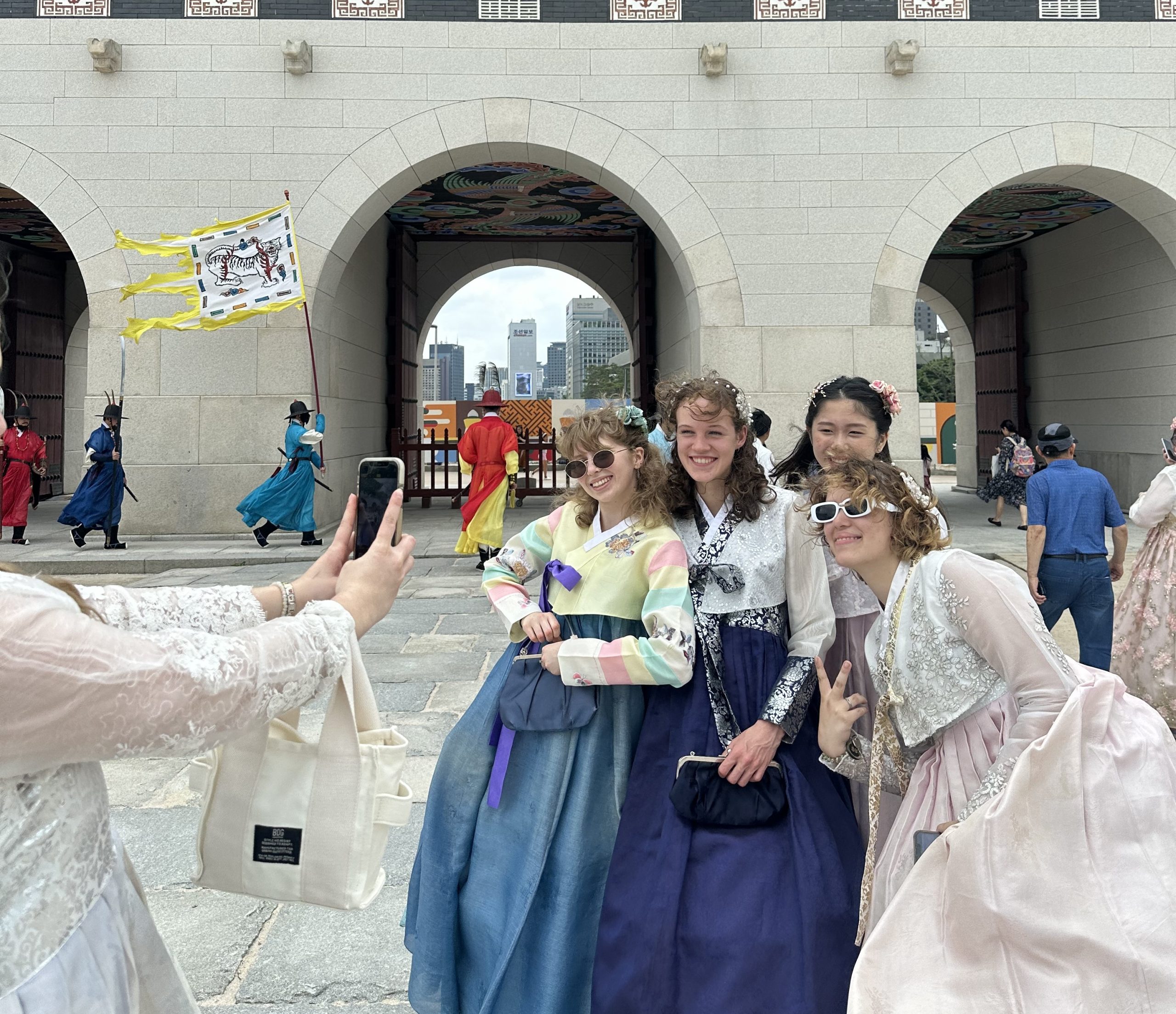 Students in traditional hanboks pose for a photo outside a palace gate in Seoul