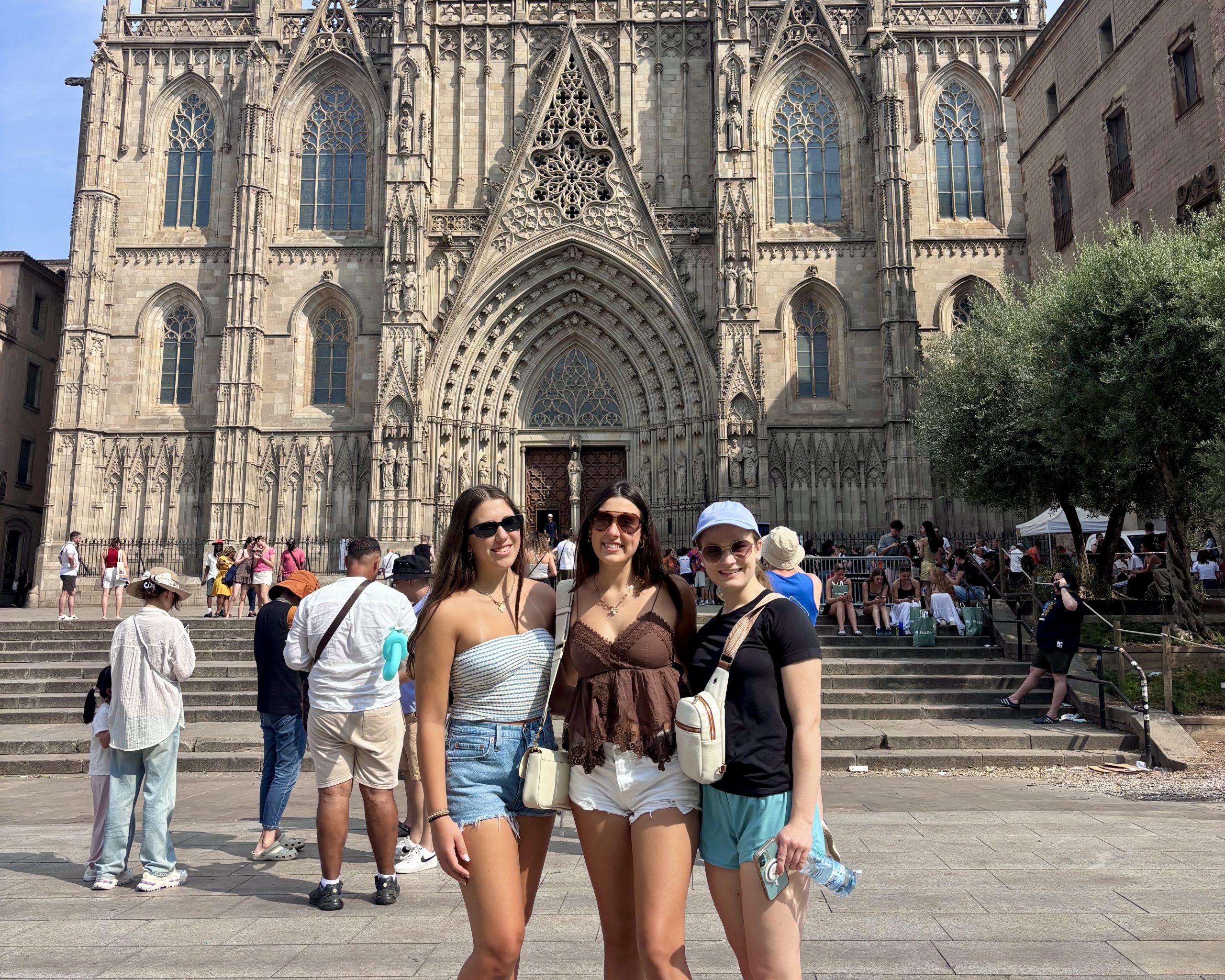 Students pose in a plaza in front of a Gothic cathedral facade