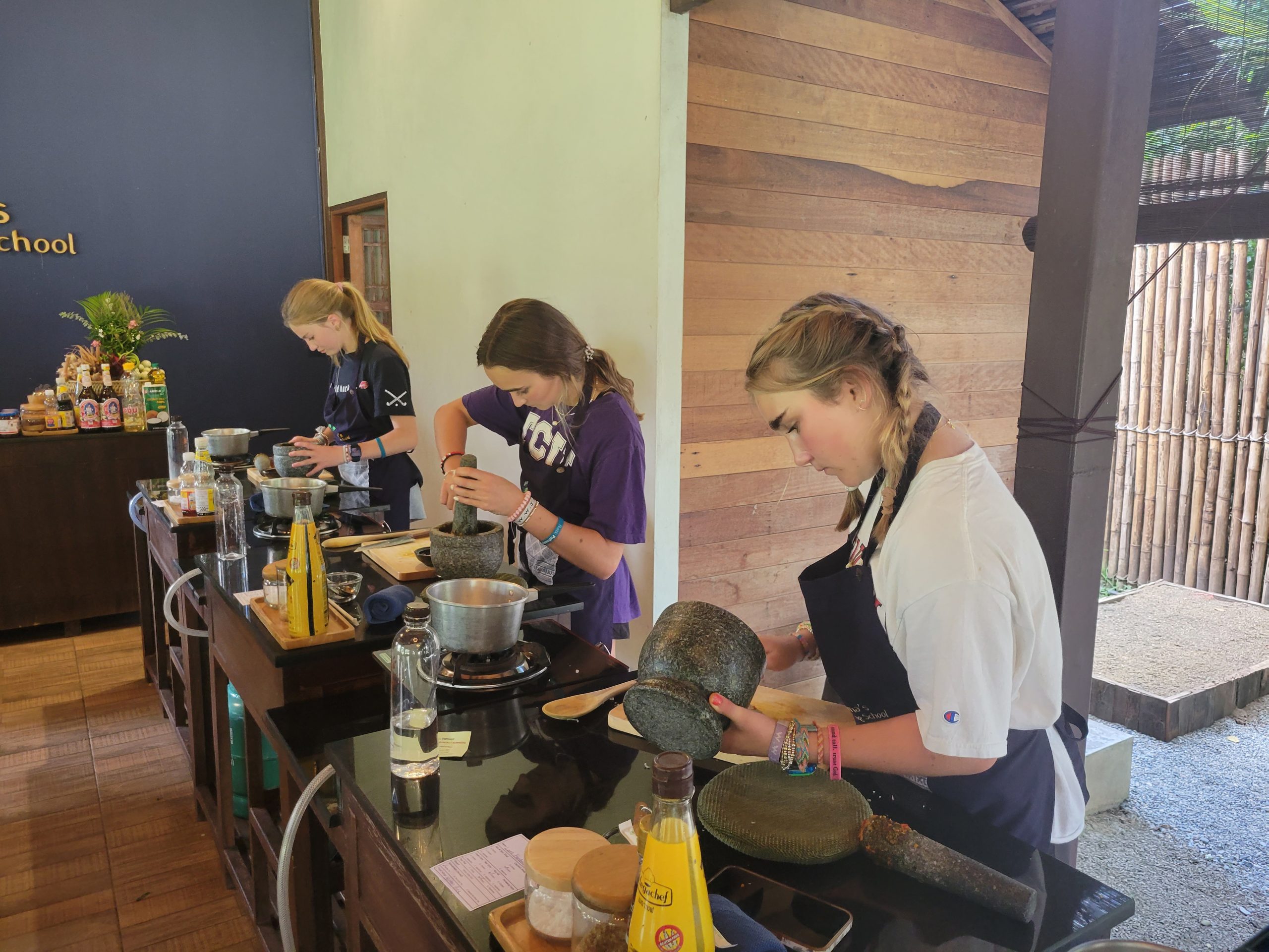 On this school trip, students use mortars and pestles at a cooking class counter