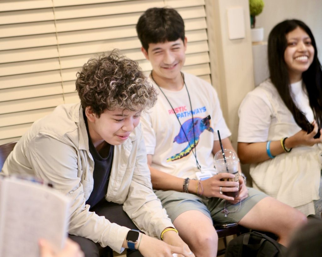 A Rustic Pathways Program Leader guiding a group of students through a reflection discussion during a service program.