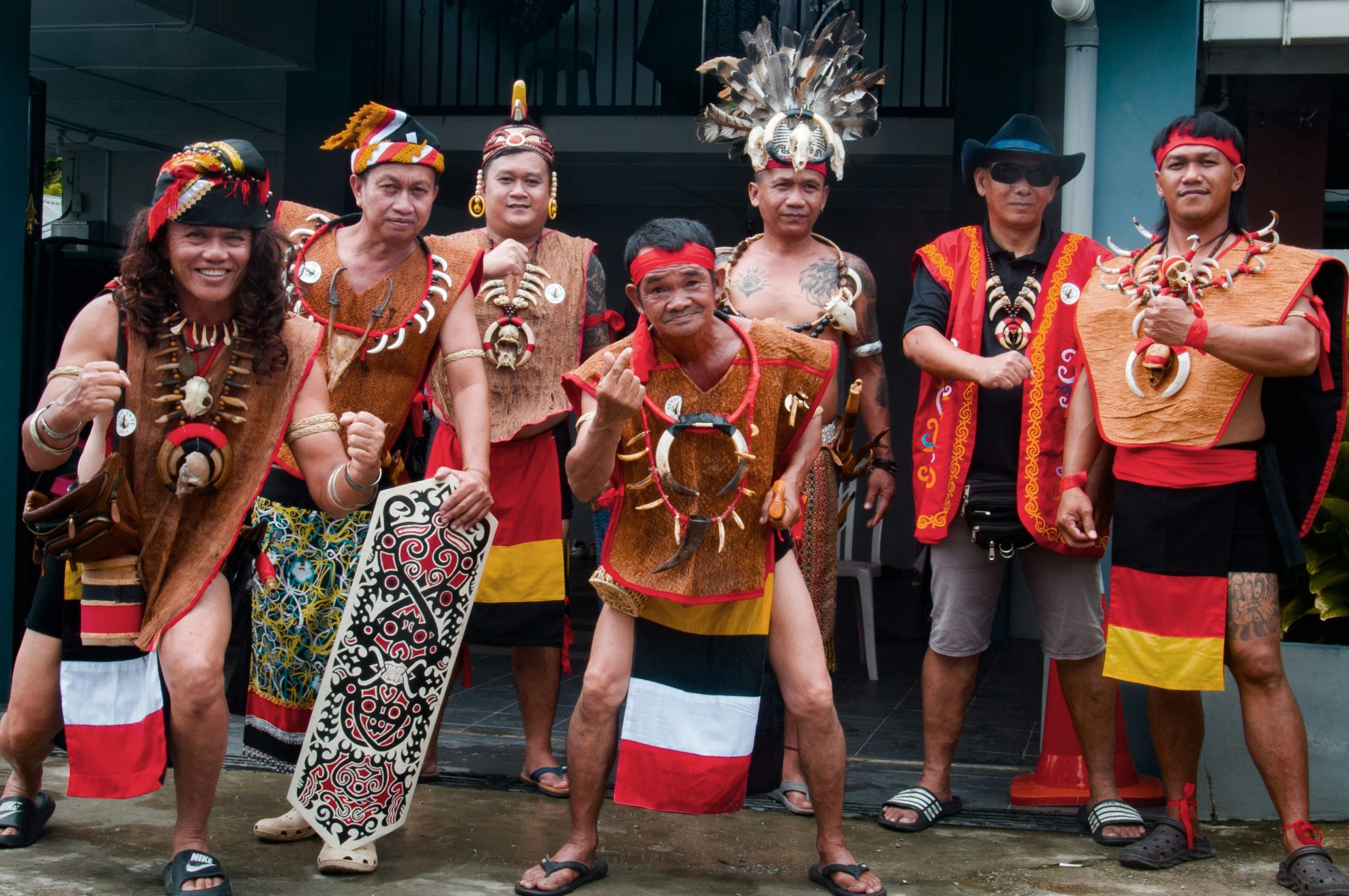 A group of men in traditional Sarawak indigenous dress pose together at a cultural gathering.