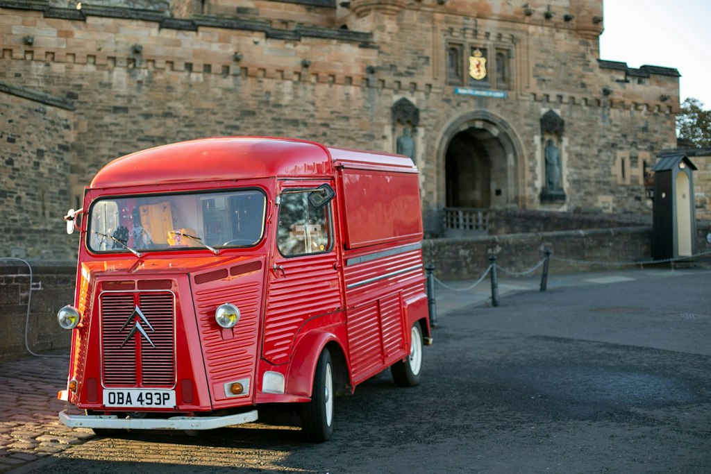 Picture of red bus in front of Edinburgh castle.
