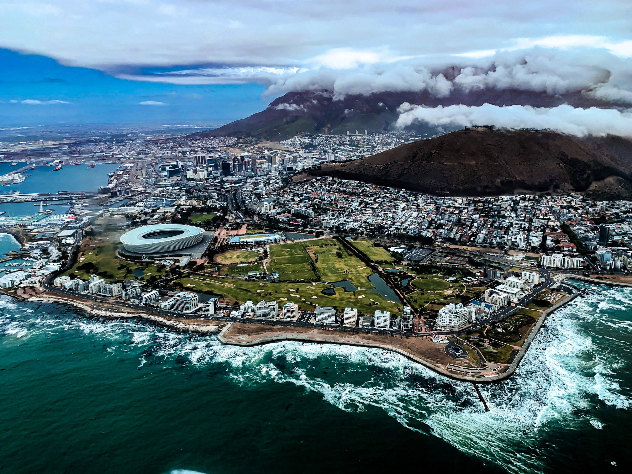 Aerial view of Cape Town's coastline with Table Mountain shrouded in clouds