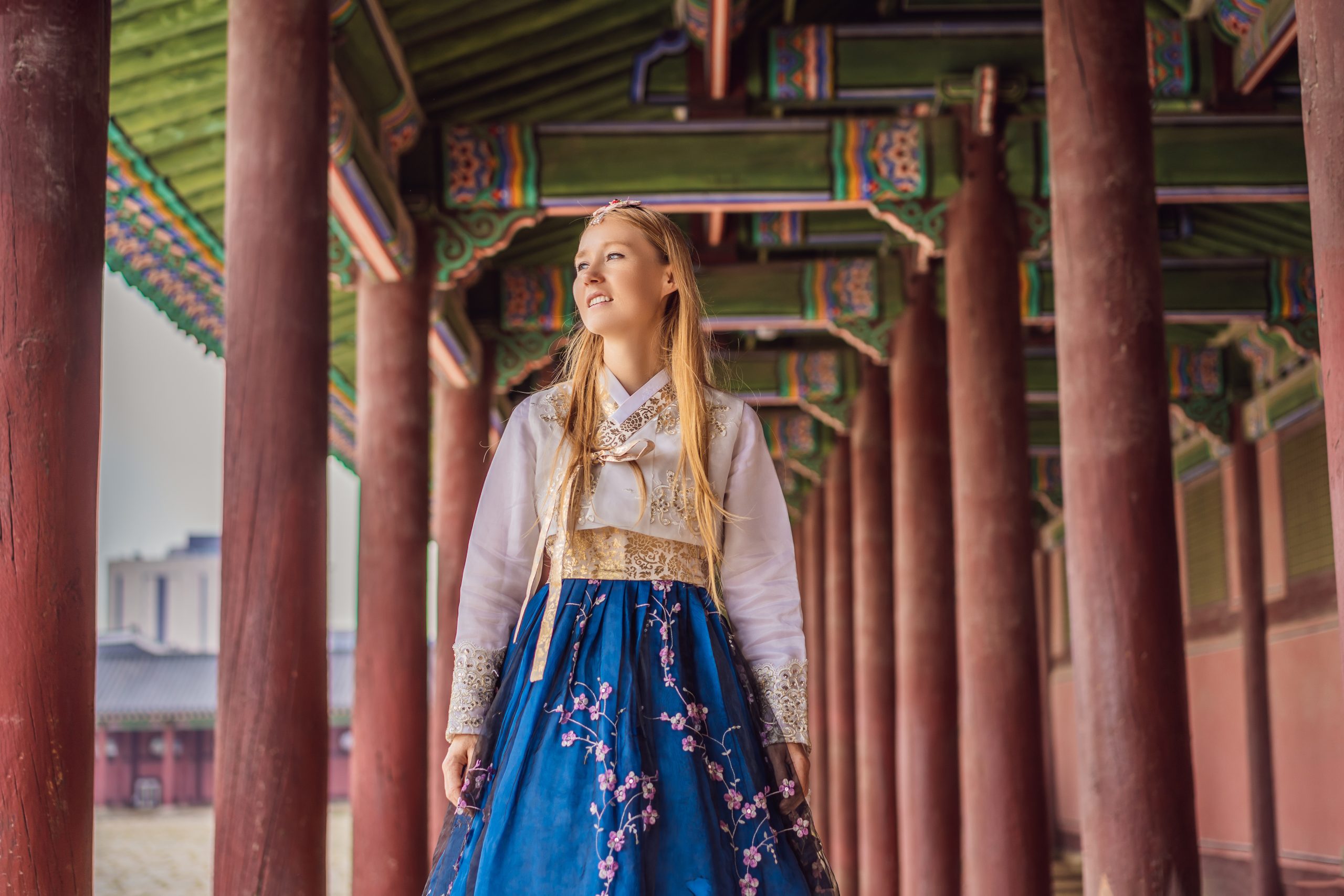 Students in hanbok near a palace gate in Seoul on a sunny day