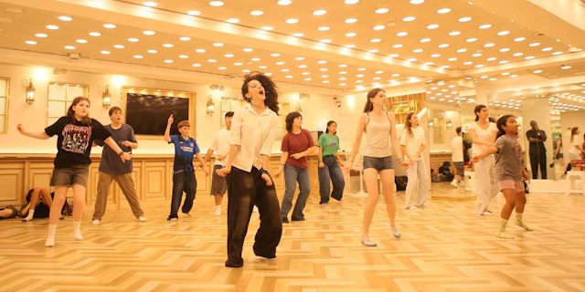 Students practice coordinated dance steps in a mirrored studio in South Korea