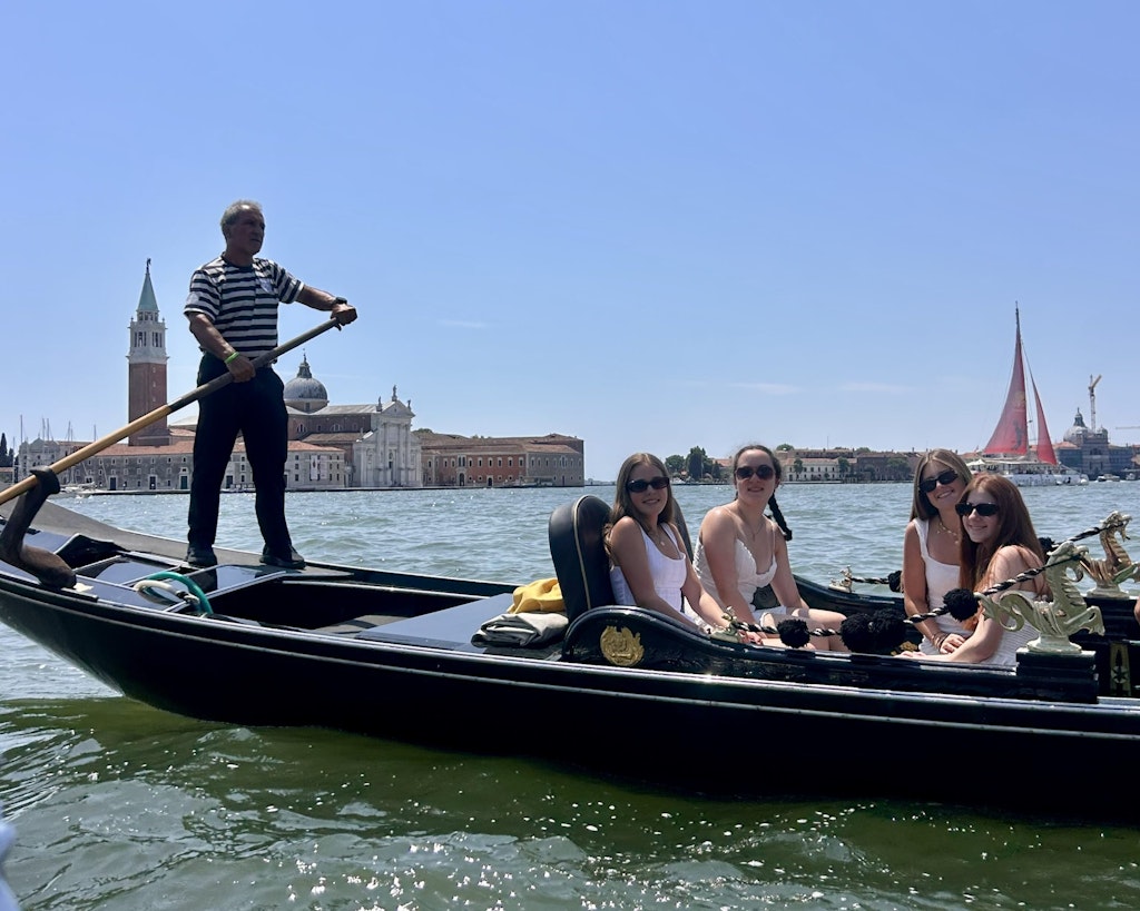 Travelers on a student travel program in Italy riding on a boat in the Venice Canals. 